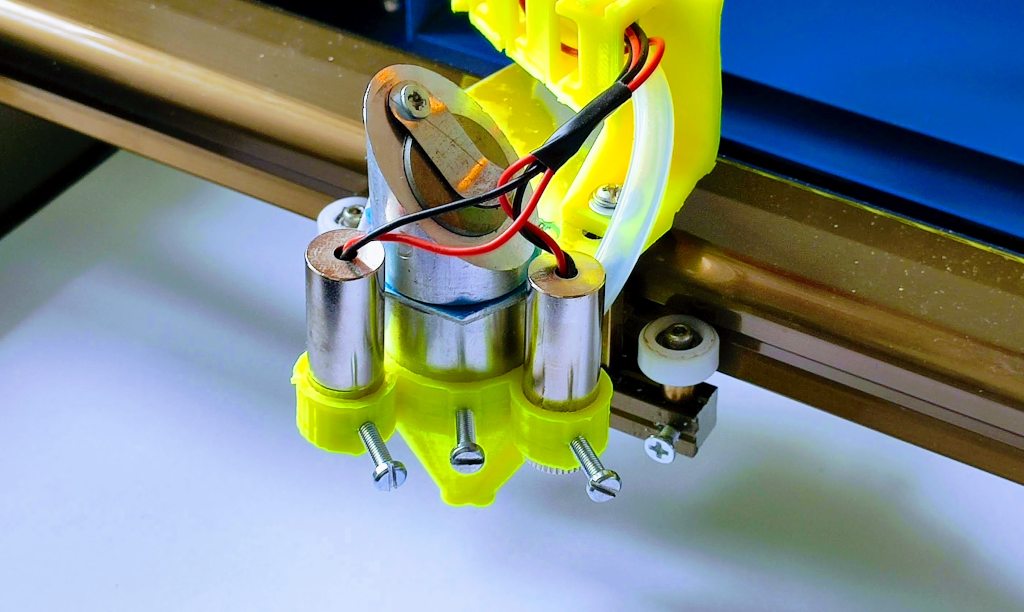 K40 CO2 laser head equipped with an air assist nozzle and diode crosshairs